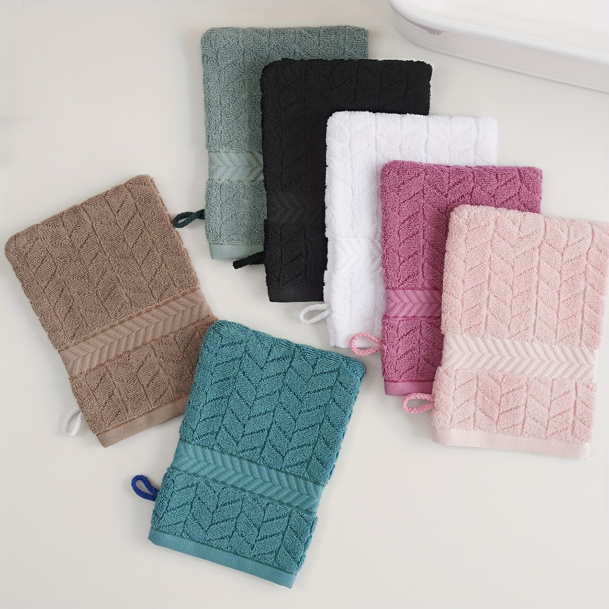 3 soft cotton bath gloves in geometric patterns for makeup removal, available in pink, green, black, white, and teal blue. Ideal for bathing and hand use.