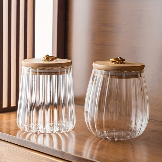 Set of 2 Japanese-style glass storage jars with sealed lids, perfect for storing tea leaves or snacks in a rustic Nordic home. Includes decorative wooden lids for organization. Great storage items for your kitchen or pantry.