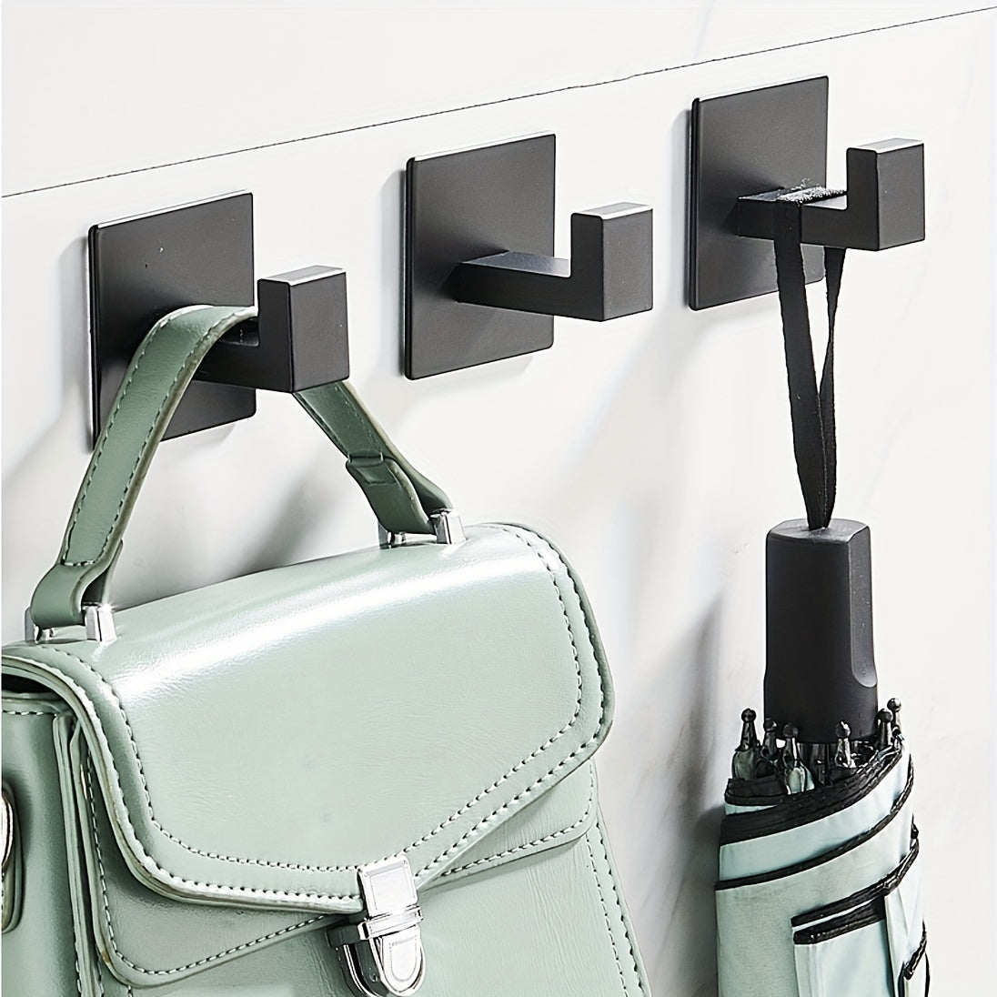 Self-adhesive wall hook for hanging keys, bags, clothes, bathrobes, coats, towels, and other accessories.