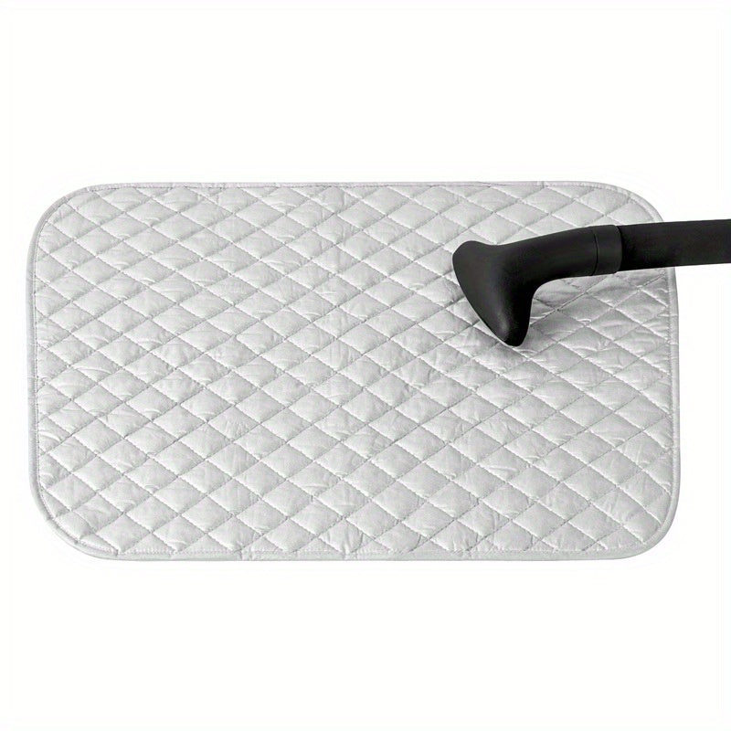 Portable ironing board with garment steaming capabilities, featuring heat insulation and high temperature resistance. This foldable mat is double-sided with a silvery, diamond lattice design for added style.