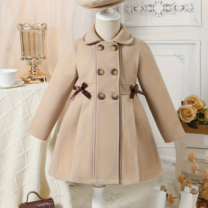 Youthful girls can look stylish in this casual polyester trench coat with lapel collar, double-breasted design, and matching bow detail and hat.