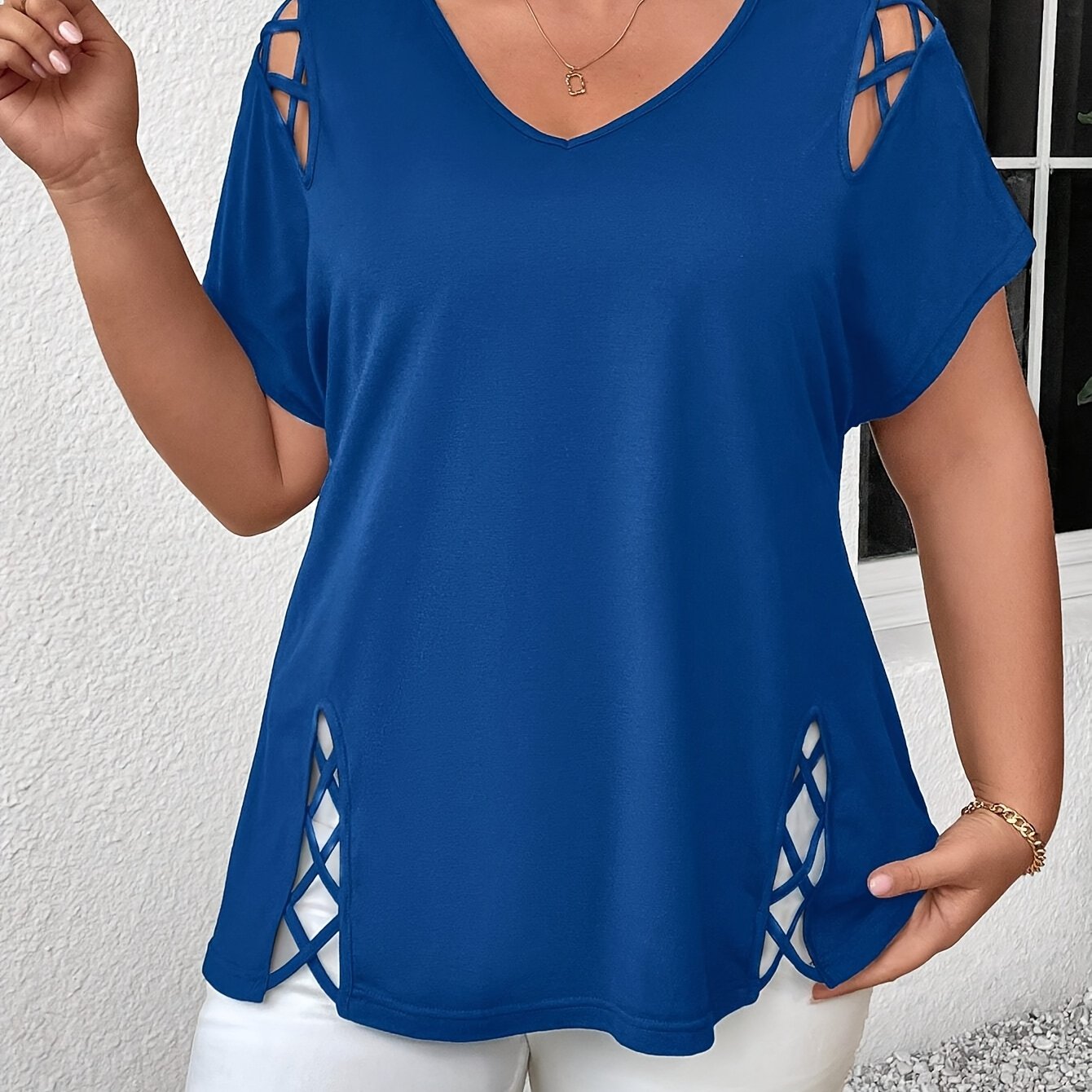 Stylish plus-size women's top with V-neck and crisscross detail, made of medium-stretch fabric, suitable for all seasons.