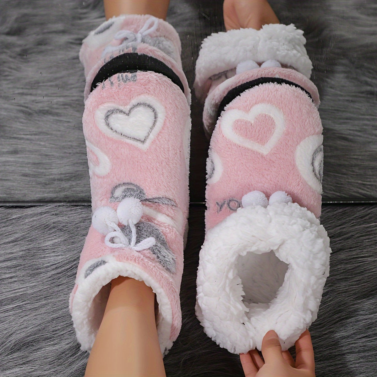 Heart-patterned slipper boots with cozy fleece lining, machine washable for indoor wear.