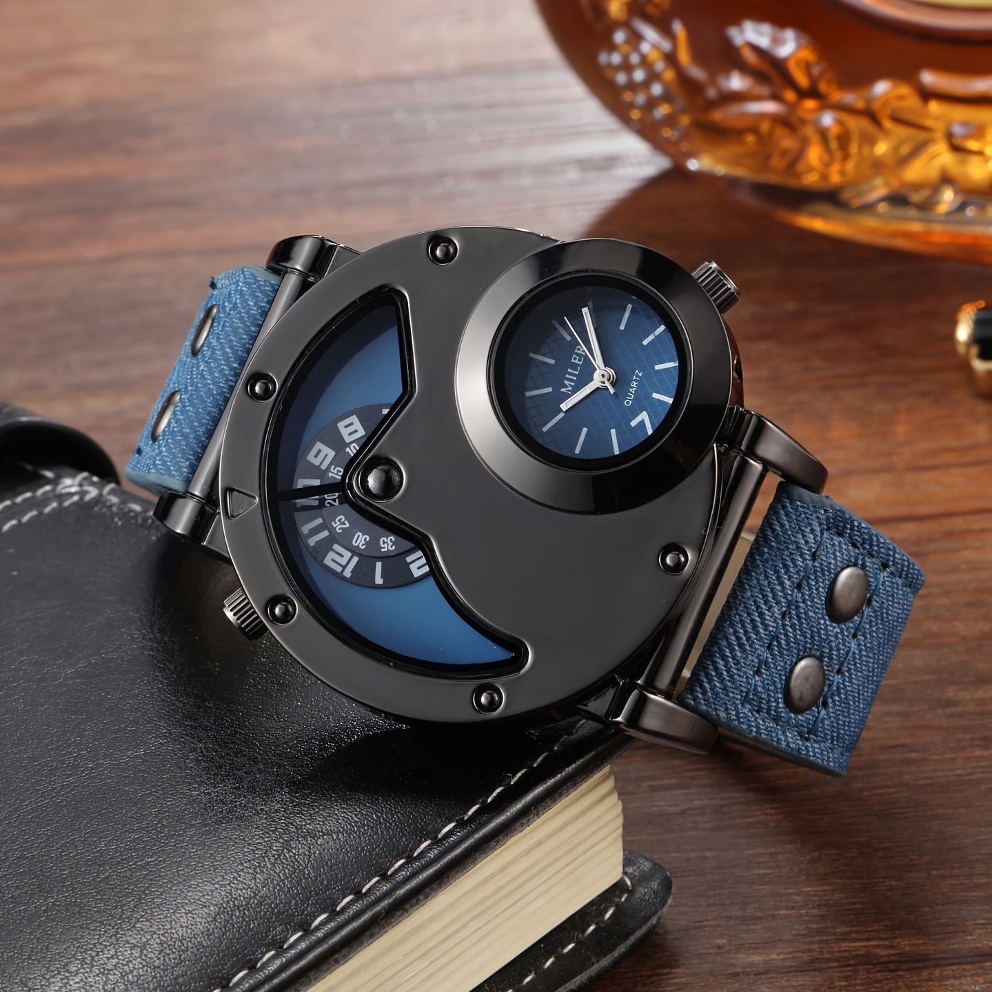 A stylish men's wristwatch features a vintage dual-time display and studded details, complete with a denim strap and round alloy case. Powered by quartz movement and an electronic drive, this fashionable large dial watch is not waterproof.