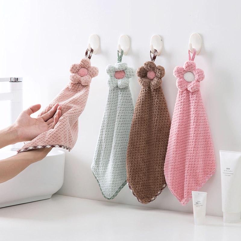 Decorative crochet flower hand towel made of absorbent microfiber with hanging loop. Perfect for kitchen or bathroom use in pink, mint green, white, or brown.