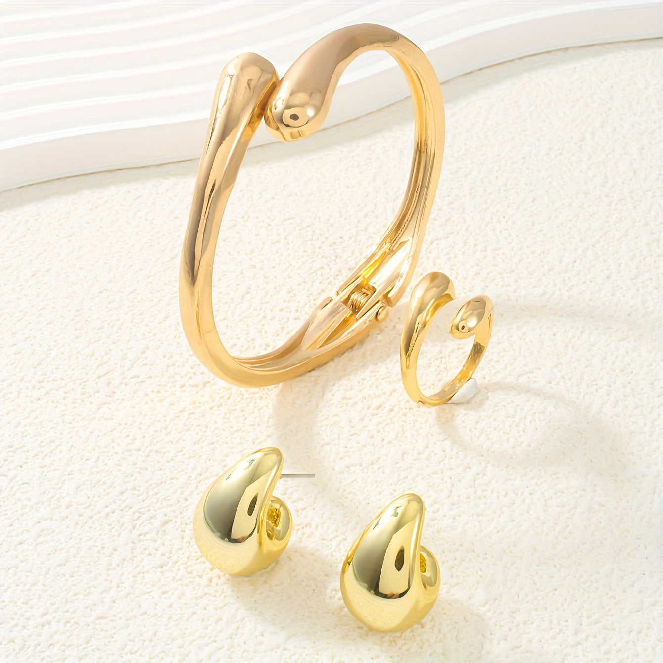 A set of women's jewelry, including earrings, a ring, and a bracelet with a spring design, ideal for everyday elegance.