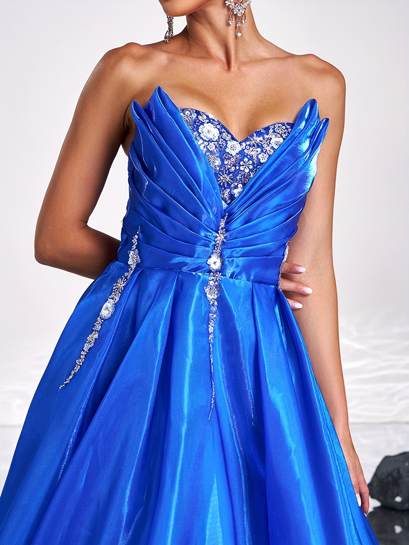 Elegant royal blue satin tube dress with rhinestone detailing and backless design, perfect for parties and formal events. Off-shoulder gown with flowing skirt and structured silhouette.