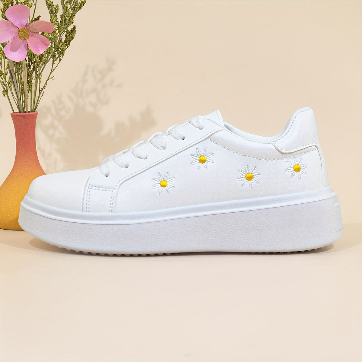 Women's low-top lace-up sneakers with embroidered daisy design, ideal for all seasons.