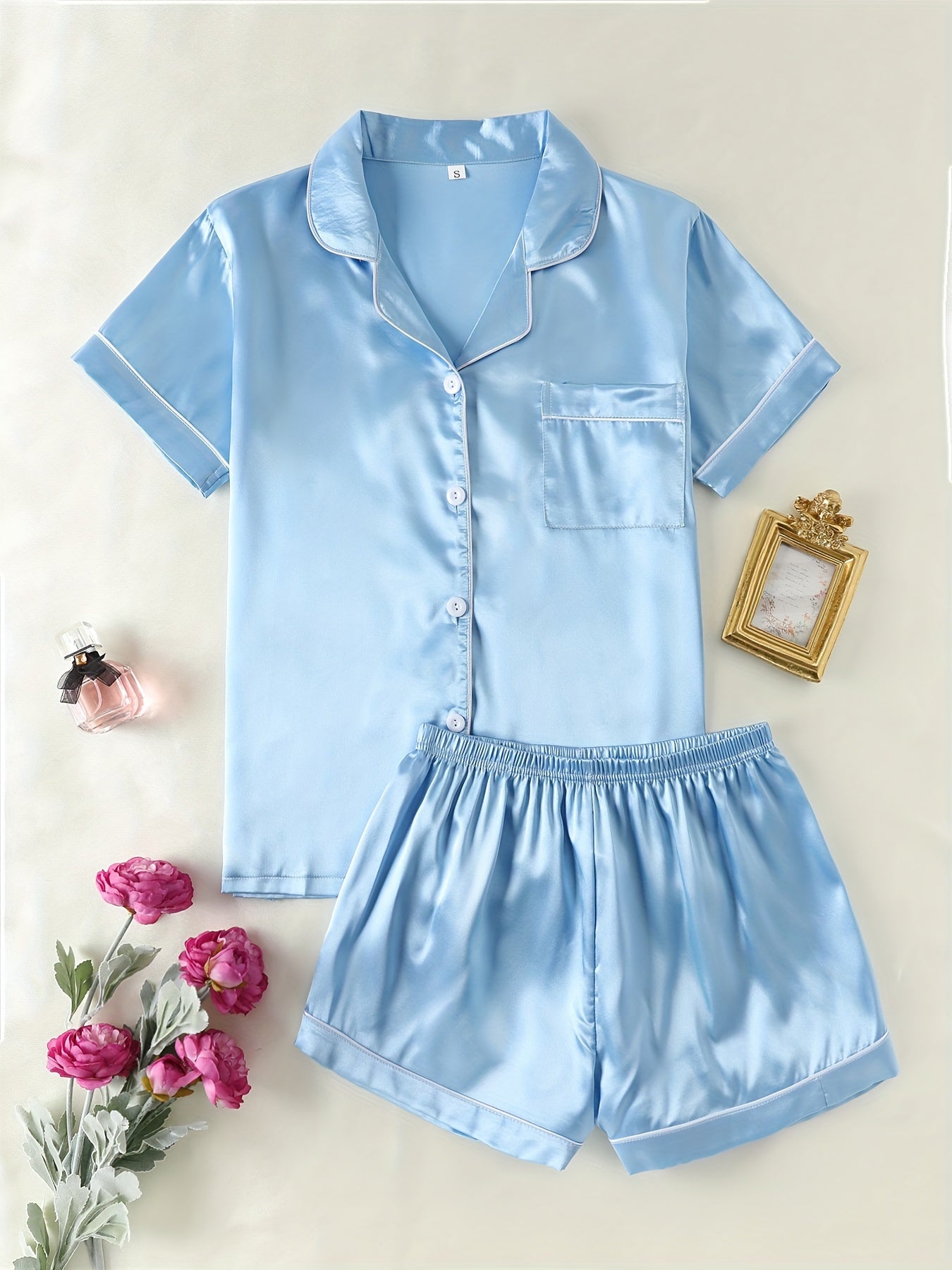 Satin lounge set includes a short sleeve button-up top with lapel collar and elastic shorts.