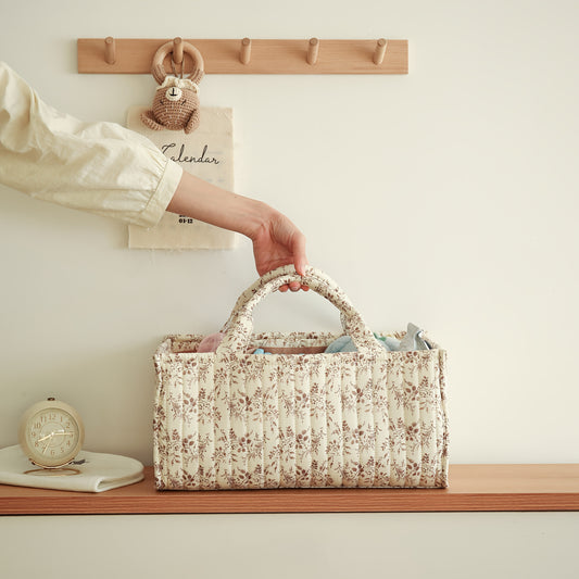 Portable nursery storage basket with handle made of polyamide, designed to organize diapers conveniently. This caddy is essential for keeping diapers, clothes, and toys in order. Perfect as a shower gift or registry item for new parents.