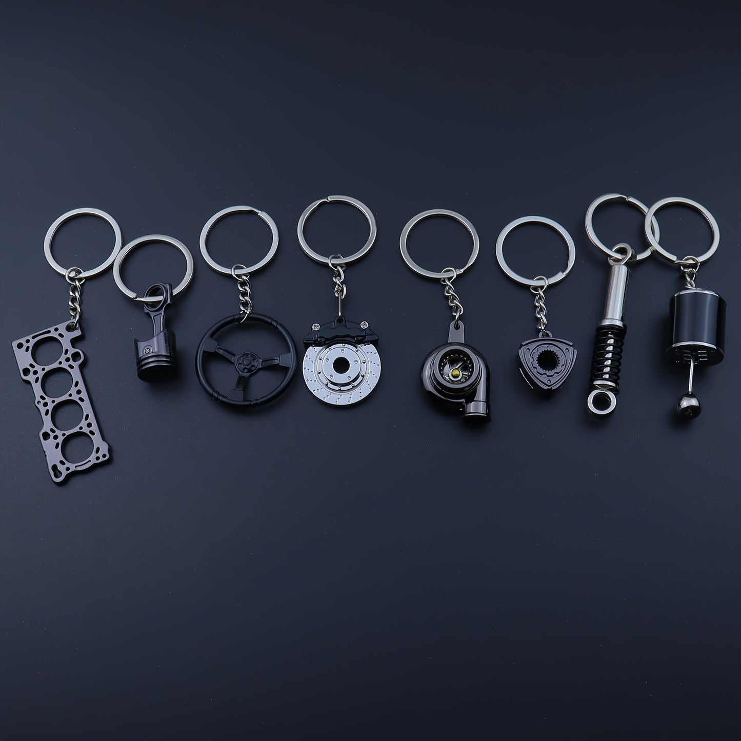 Keychains for creative car modifications, including piston, brake disc, gear, turbocharger, small rotor, shock absorber, engine blade, and steering wheel designs. Perfect for car enthusiasts and as a unique gift.