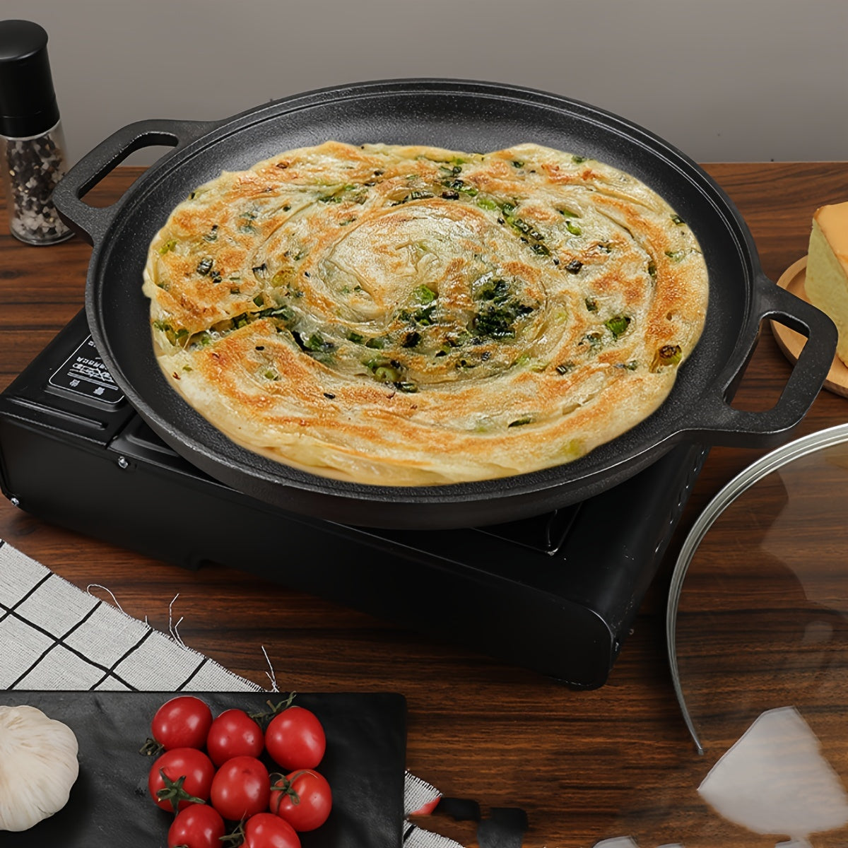 Double-handled non-stick frying pan for pancakes made of cast iron, meant for hand washing, with a durable uncoated surface ideal for cooking crepes and flatbreads.