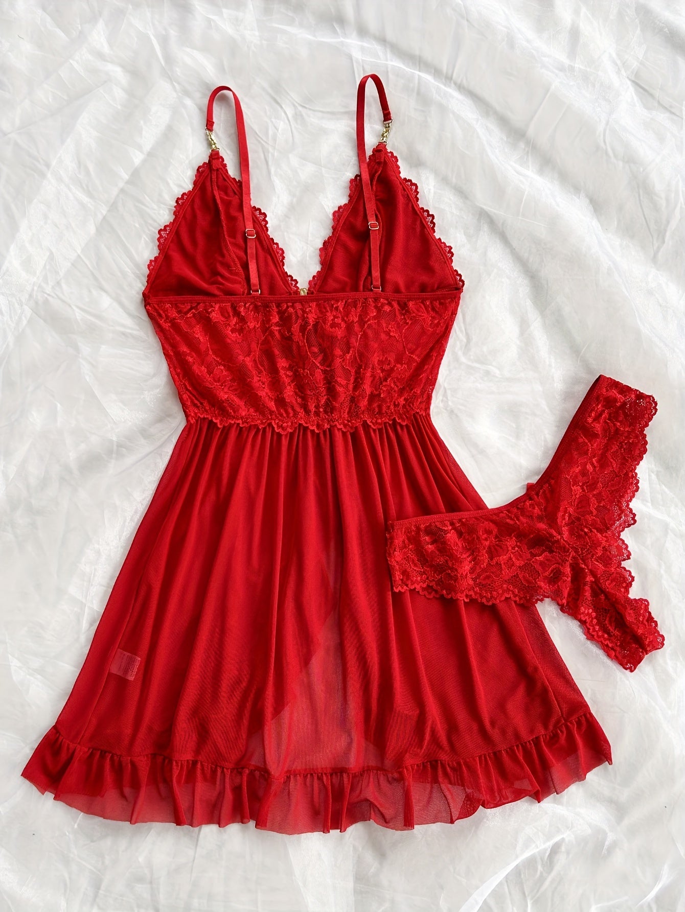 Stylish lace slip dress pajama set with V-neck, backless design, ruffle hem, and shorts. Made of breathable polyester blend, suitable for all seasons.