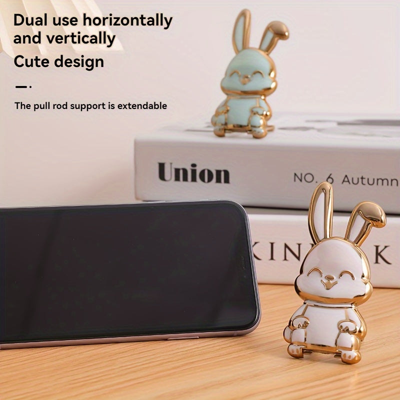 Foldable waterproof phone stand made of ABS material, featuring an adjustable cartoon bunny design for holding smartphones and tablets.