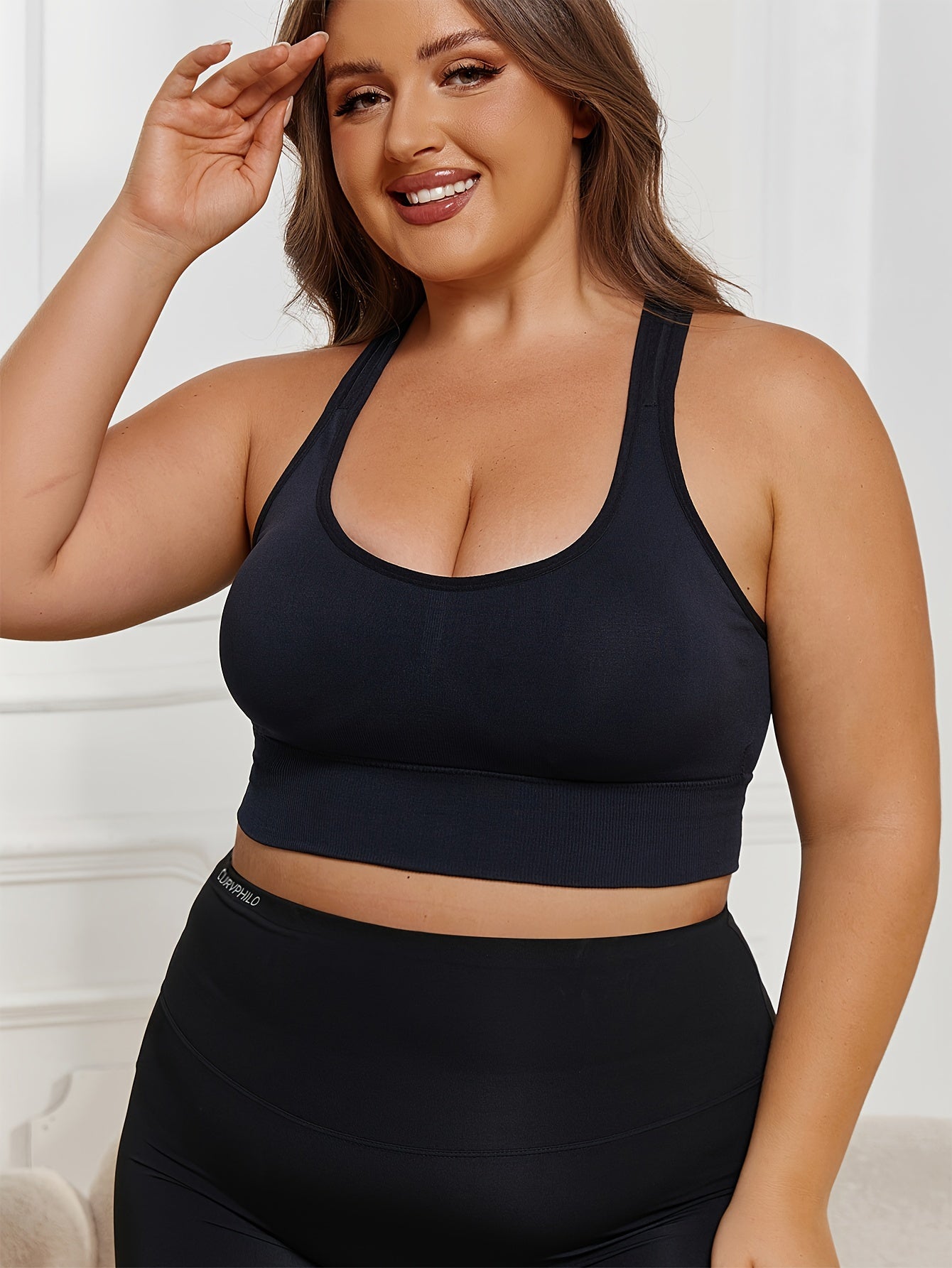 Plus Size Seamless Sports Bra made of solid color knit fabric with medium stretch, composed of 83% polyamide and 17% elastane. Features removable padding, wireless design, and a lightweight