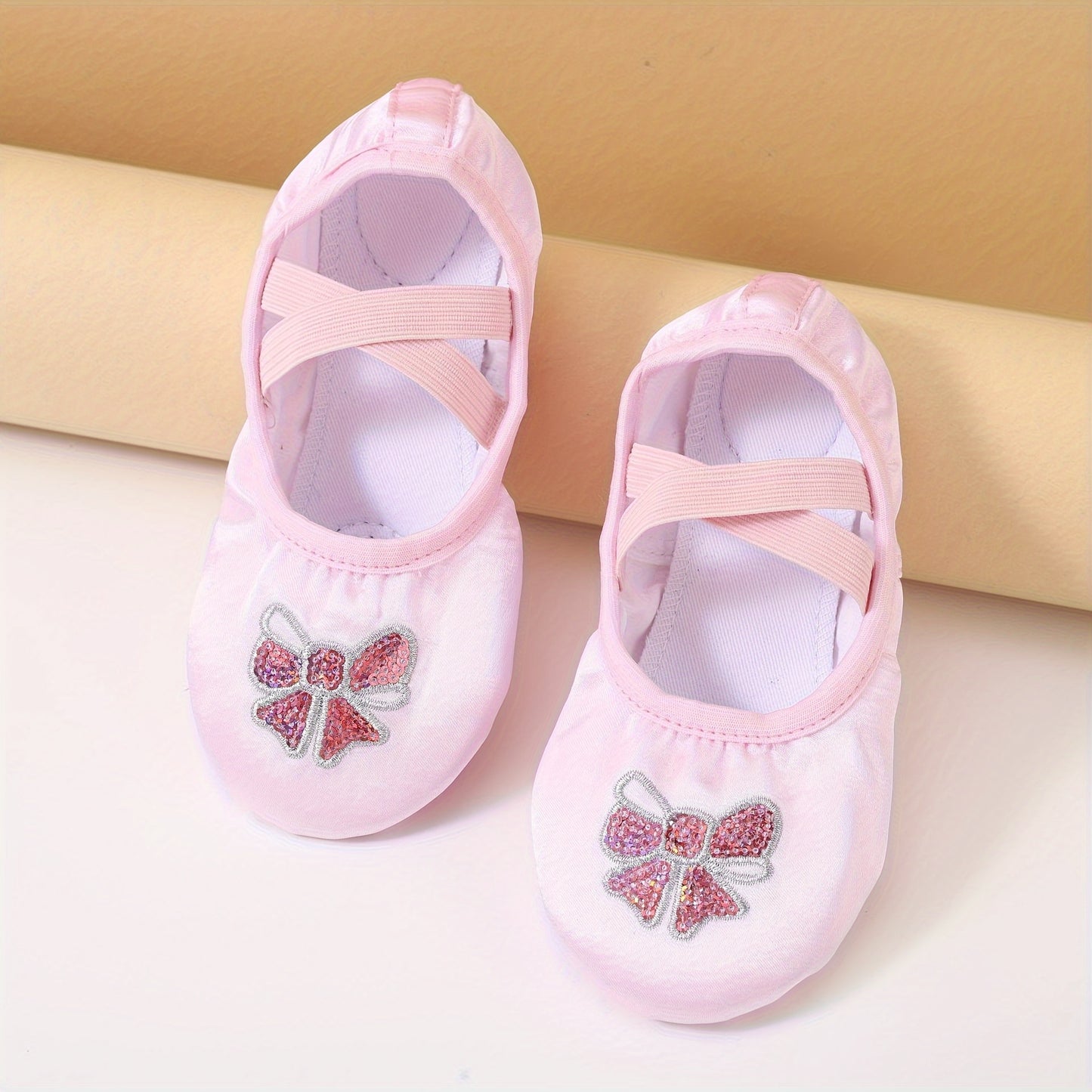 Girls’ ballet dance shoes with sparkling sequin and embroidered bow detail, soft sole, breathable canvas slip-ons. Available in pink and peach.