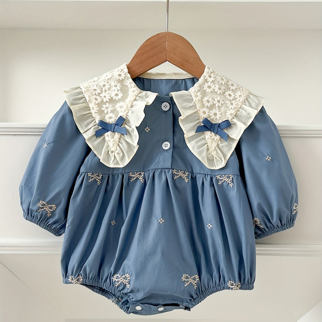 Stylish floral embroidered long-sleeve romper for baby girls, made of cotton with bow detail, ideal for spring/fall and outdoor wear.