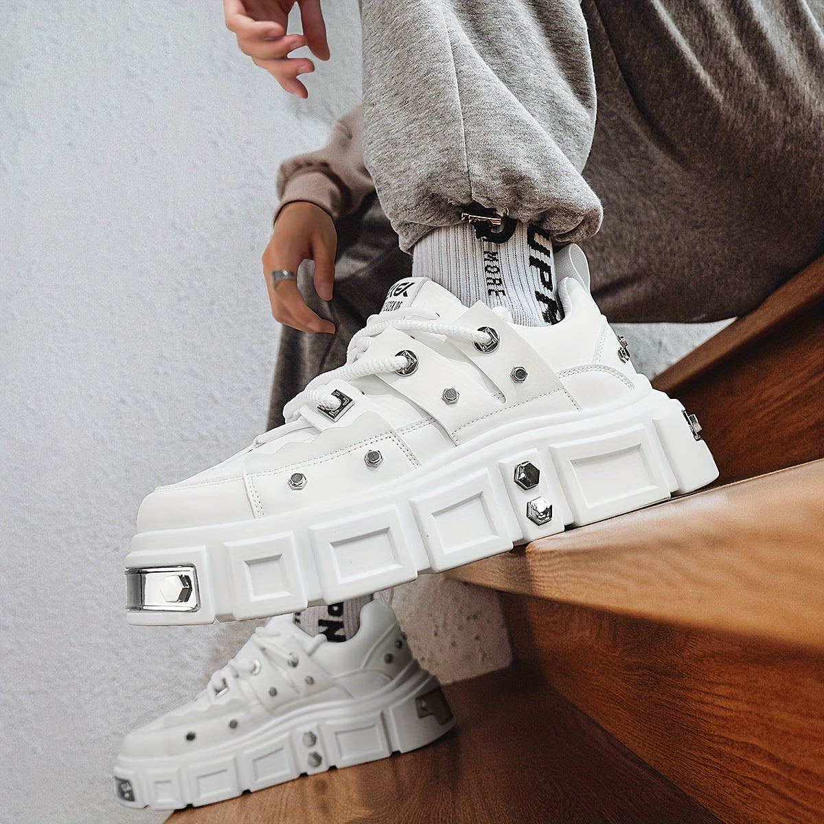 Chunky, punk-inspired sneakers with metal stud accents. Streetwear fashion statement in white, thick-soled trainers. Ideal for skateboarding, parties, and everyday wear. Unisex.