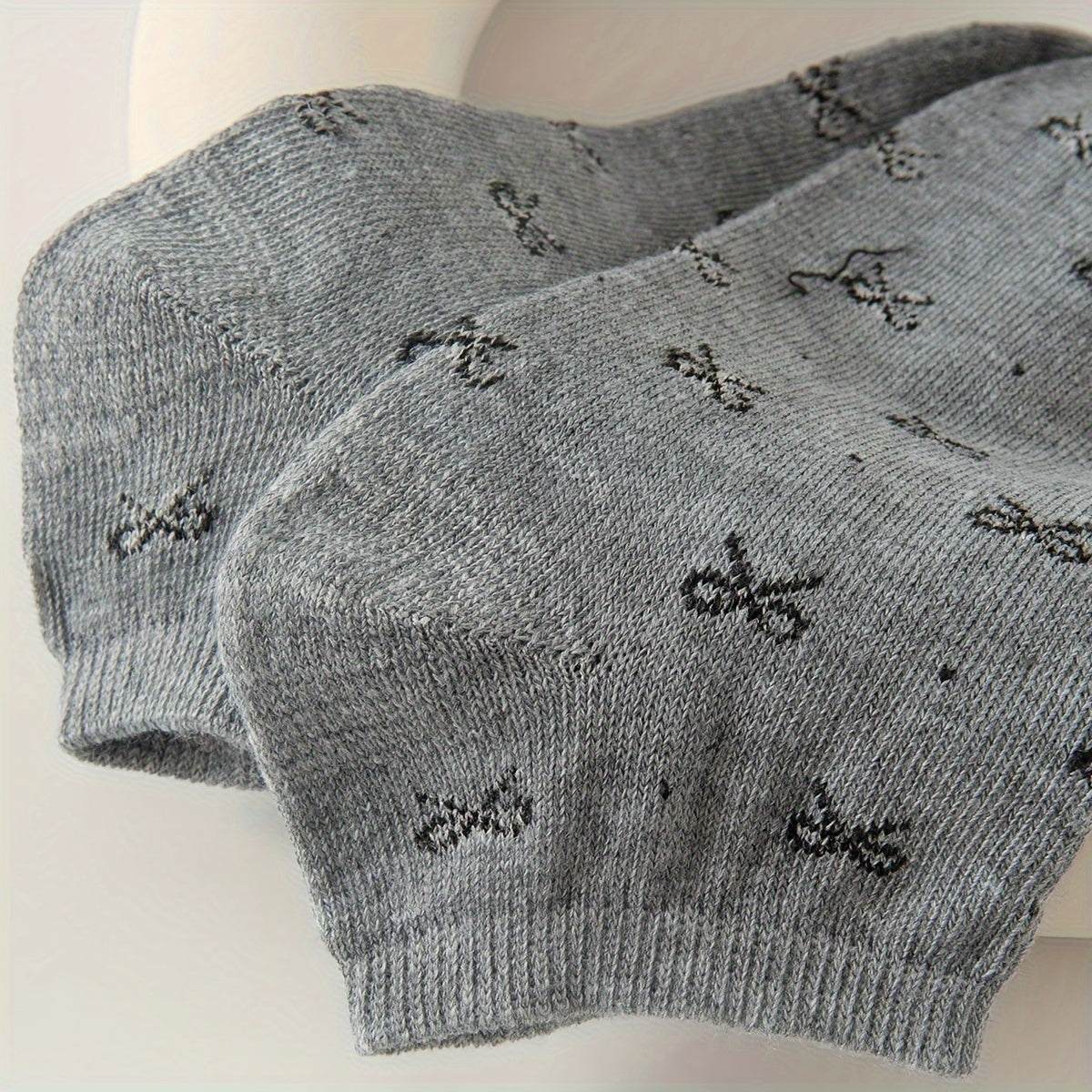 Women's ankle socks in black and grey with assorted geometric patterns. Made from comfortable knit fabric, 95% polyester and 5% spandex. Random style shipping. 10/20 pairs available.