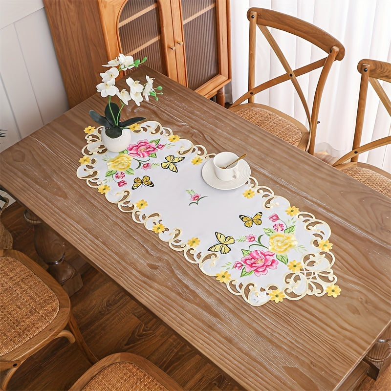 Elegant polyester table runner with hand-cut embroidered flowers and butterflies, perfect for home decor, restaurants, picnics, and parties. White base with vibrant floral patterns.