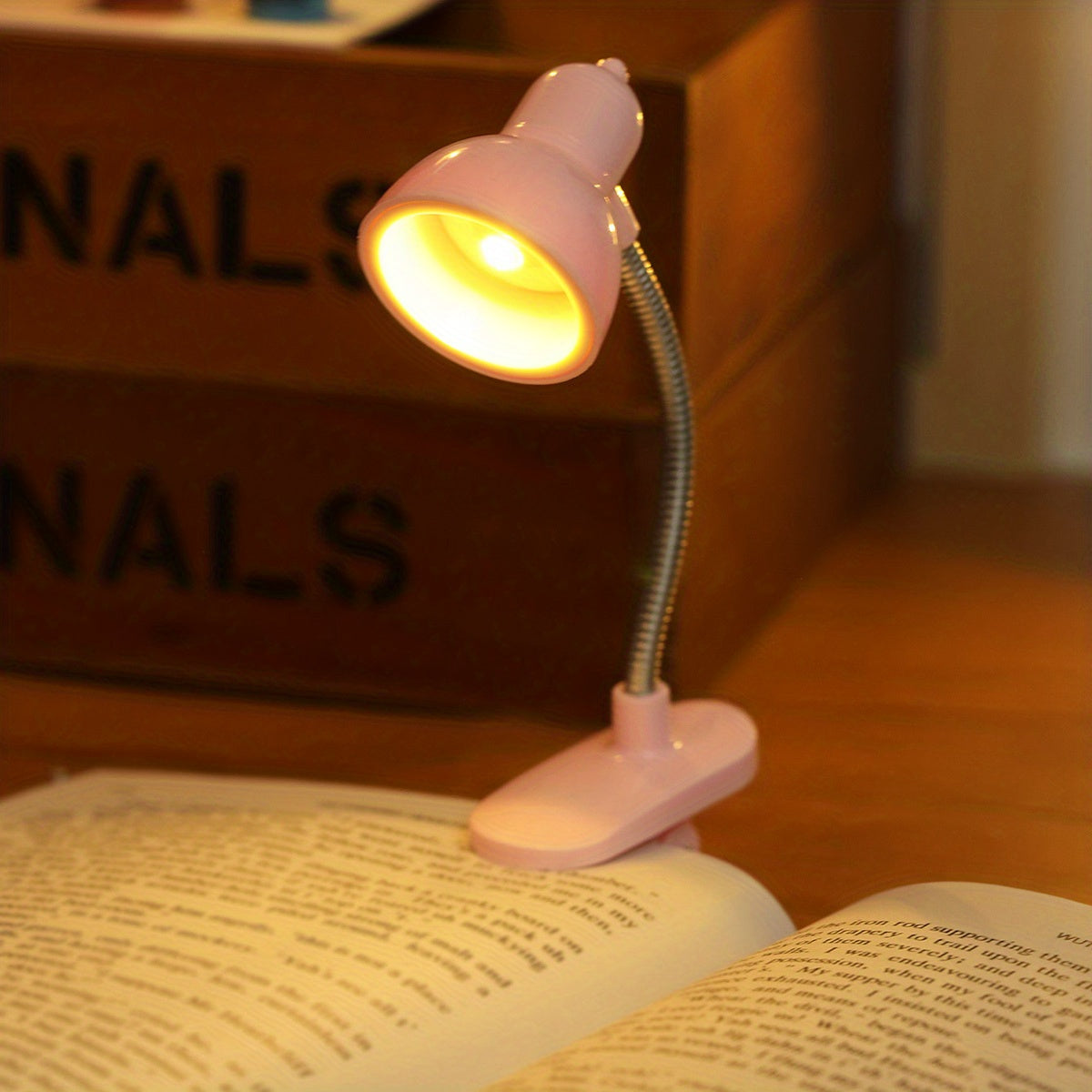 Mini clip-on reading lamp with push button control, adjustable arm, and fantasy-themed brushed finish made of plastic material. Battery operated for bedroom tabletop use as a night light.