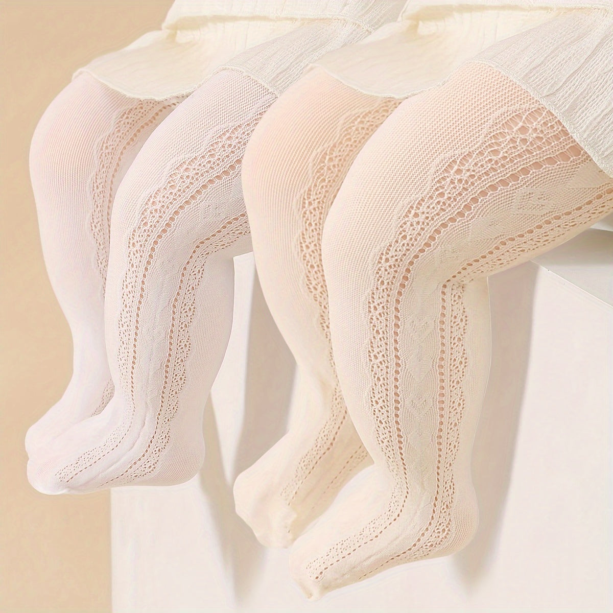 Two pairs of girls' white and beige princess-style tights with heart pattern and breathable comfort.