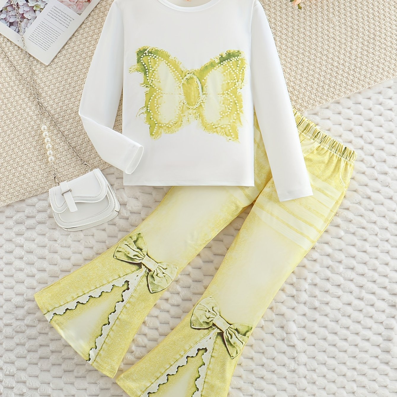 Girls' outfit set includes a long sleeve top with butterfly print and flared faux denim pants with a bow detail. Made of slight stretch knit fabric with an animal pattern, this regular fit