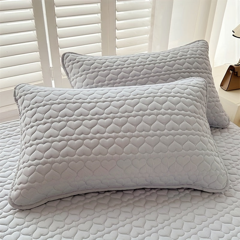 Two quilted pillowcases with waterproof lining, designed to be thick, oil-resistant, and machine washable in a stylish white and light gray color. Featuring an envelope closure, these pillowcases measure 48.26x76.2 cm and are perfect for home, hotel, or