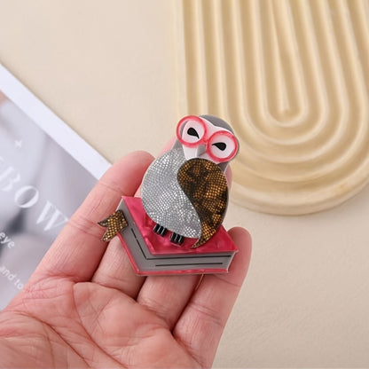 Novel and fashionable, this cute acrylic brooch features a cute bird standing on a book and wearing glasses. It is designed with an anti-see-through cartoon chest flower and retro pin for added decoration. Suitable for both men and women, this versatile