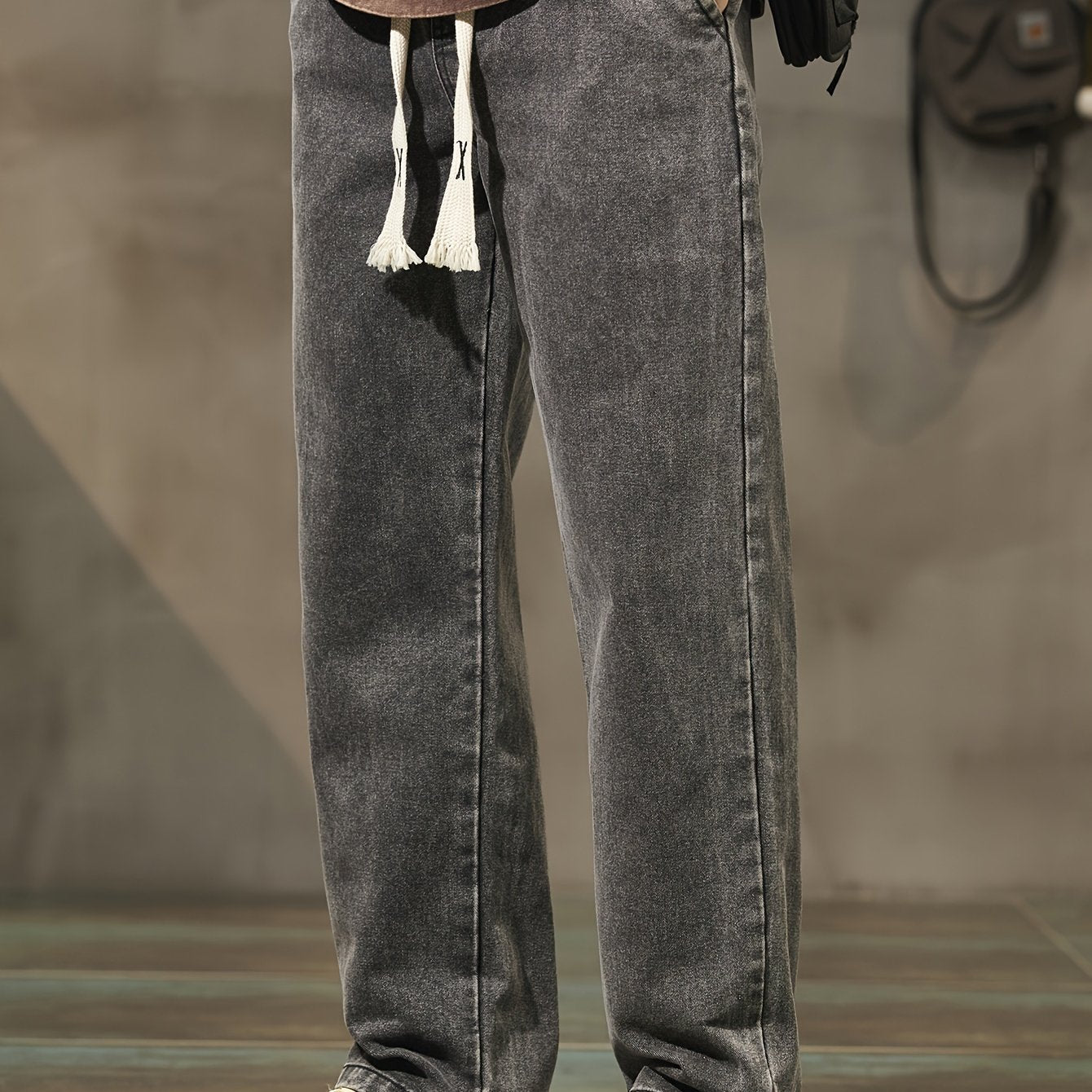 Men's denim pants with pockets, drawstring waist, suitable for outdoor activities.