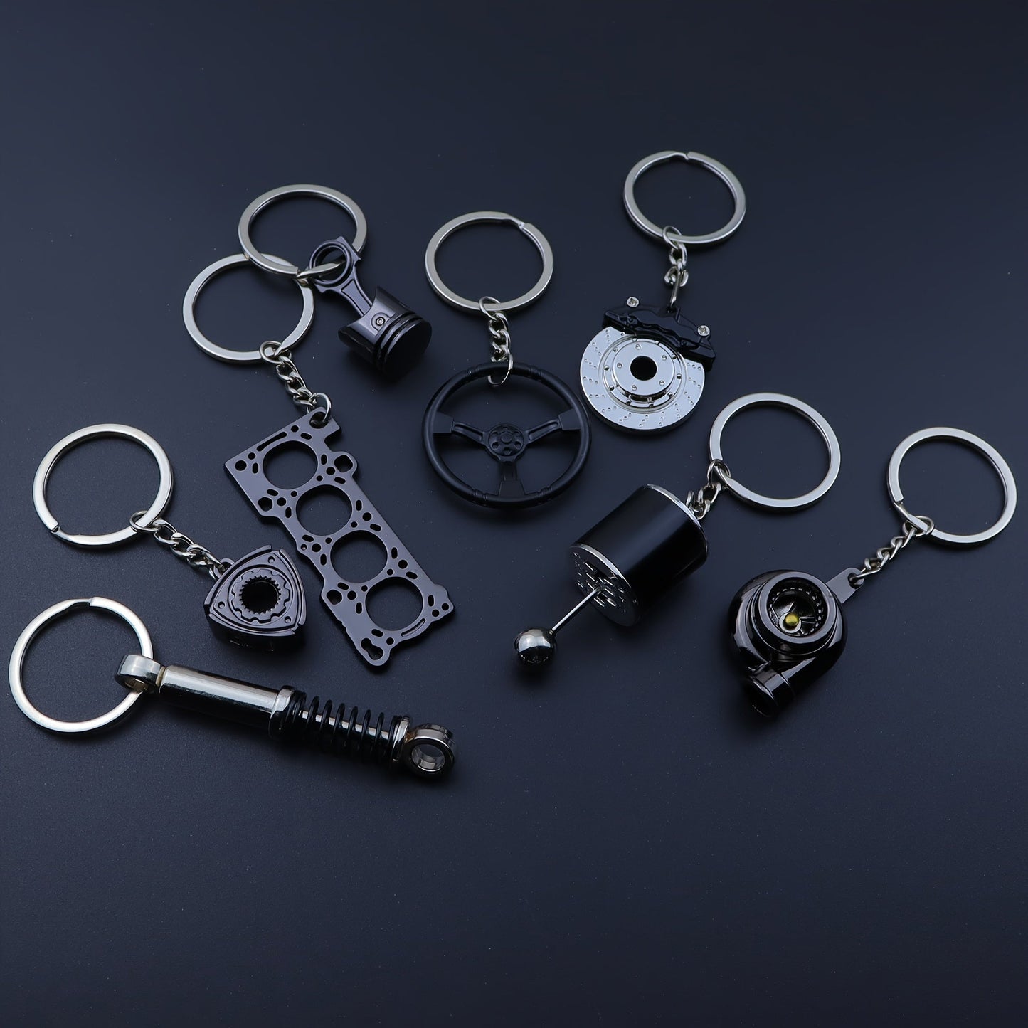 Keychains for creative car modifications, including piston, brake disc, gear, turbocharger, small rotor, shock absorber, engine blade, and steering wheel designs. Perfect for car enthusiasts and as a unique gift.