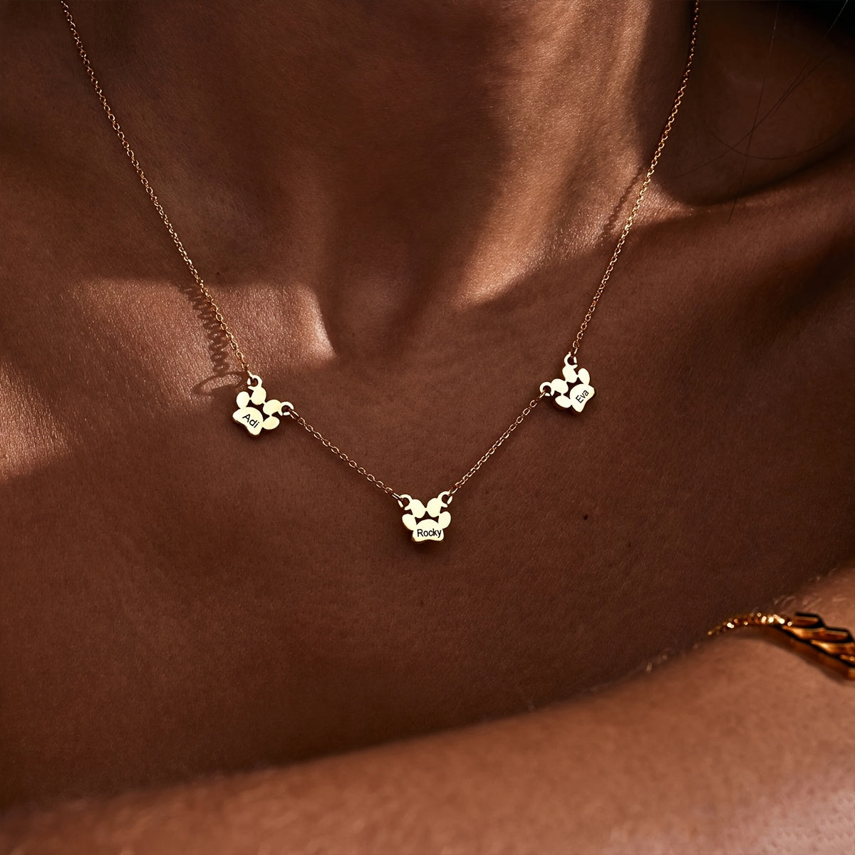 Get your hands on this exquisitely crafted 18K gold-plated copper pet paw necklace, featuring custom engraving of your pet's name and claws design. The cute and simple script and numeric symbols make it a stylish accessory perfect for everyday wear or