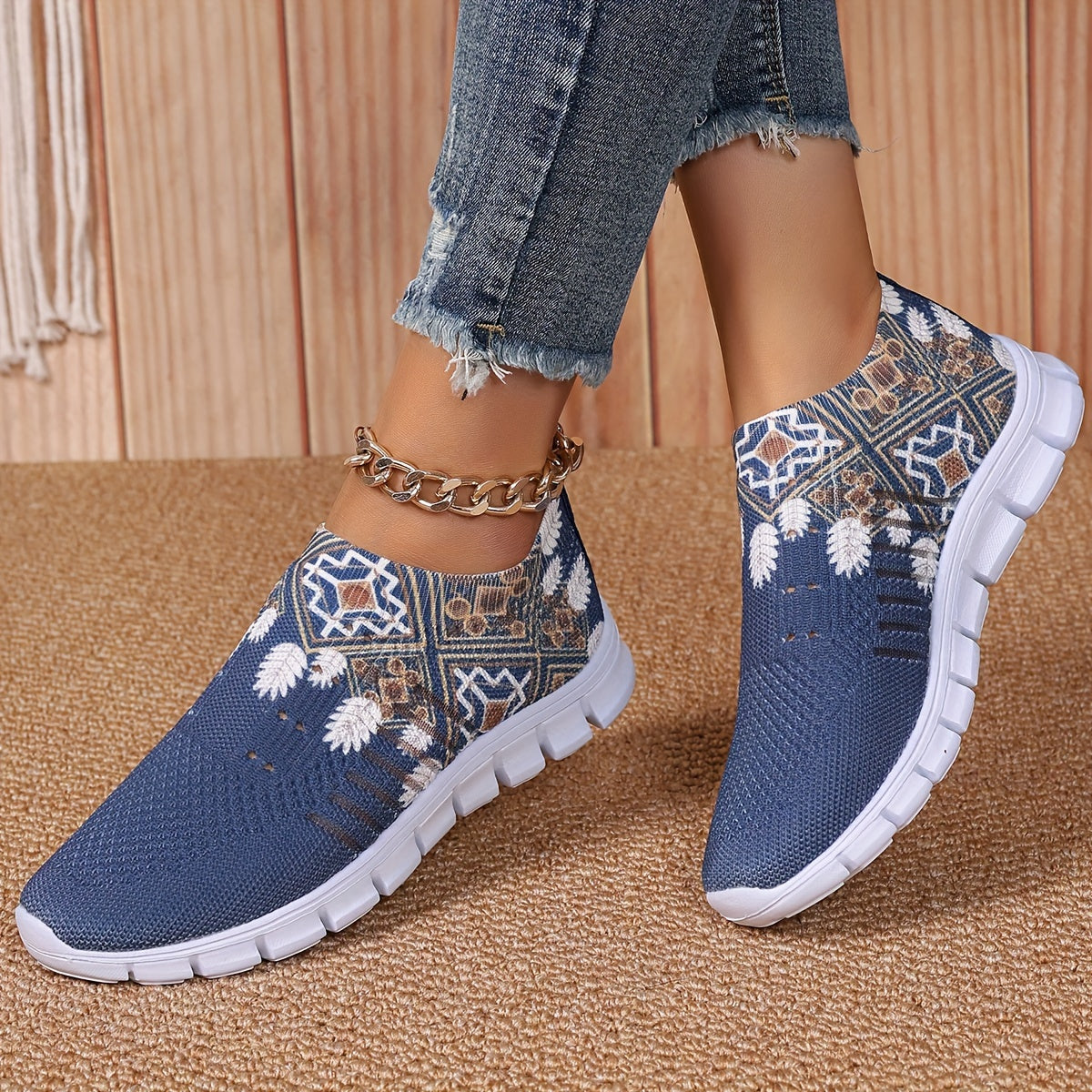 Women's casual slip-on sneakers in blue knit fabric with white floral and geometric patterns, featuring a lightweight EVA sole and breathable low-top design. Perfect for everyday wear with