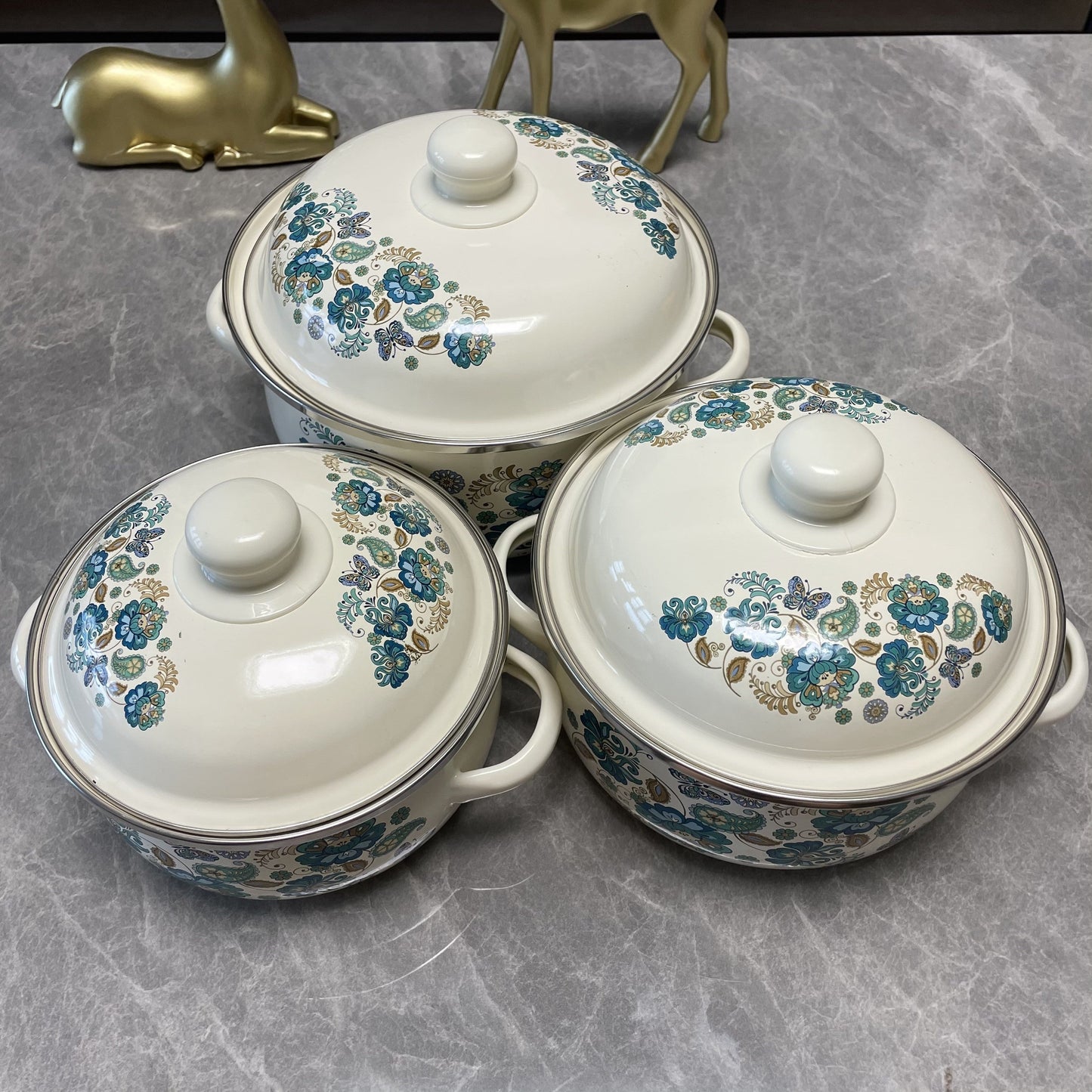 This 3-piece Enamel Cookware Set features a beautiful Floral Design, including pots perfect for soup, stew, and boiling. These versatile pots are ideal for use in the kitchen, and can be used on gas, electric stoves, and open fires. Please note that they