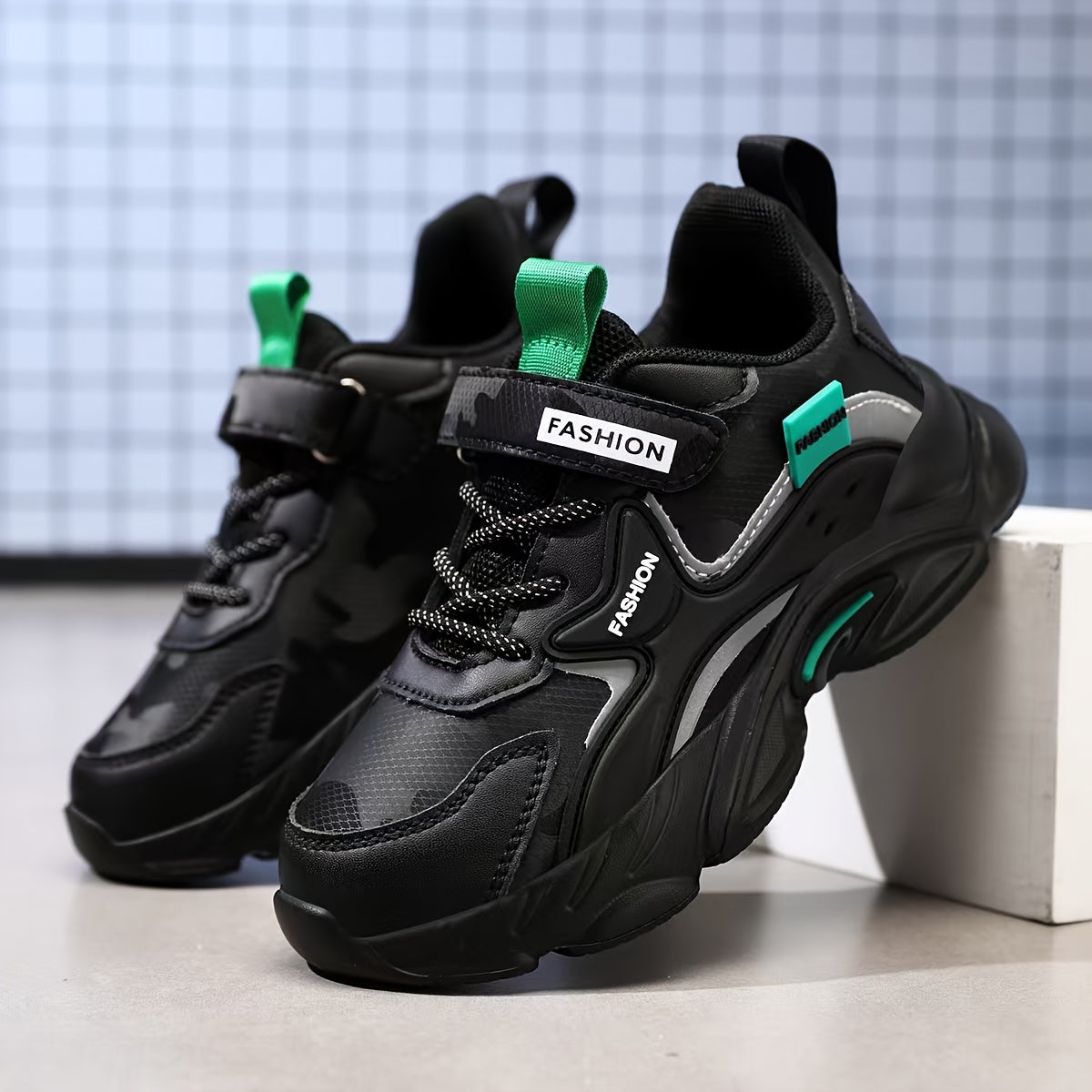 Fashionable boys' athletic sneakers with waterproof, breathable mesh upper and hook-and-loop closure in black and teal design. Ideal for running, sports, and casual wear. Features a stylish