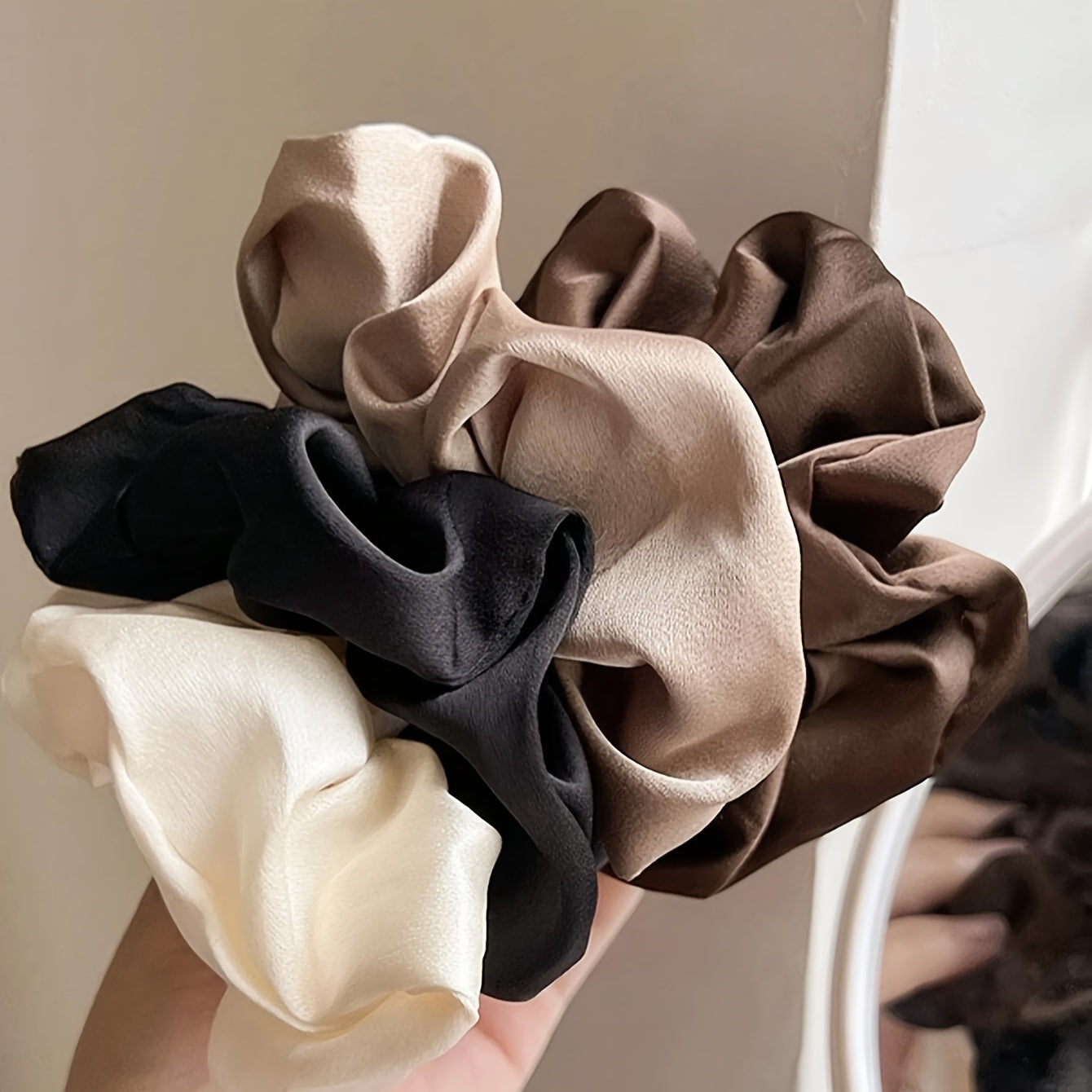 5 elegant and versatile hair scrunchies in classic black, white, and brown suited for all ages.