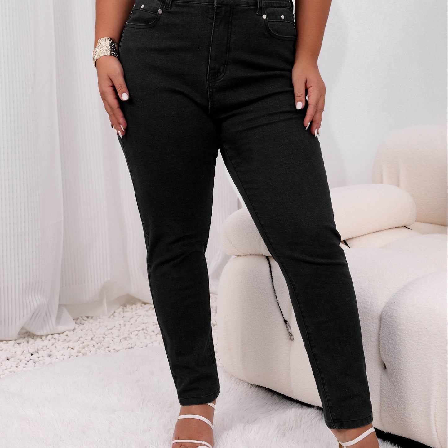 Women's plus size high-rise jeans with solid color and button fly, offering a comfortable stretch fit.