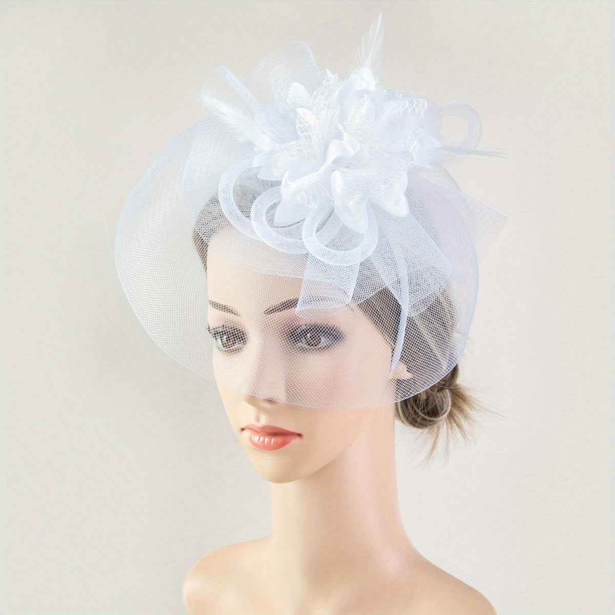 One piece of women's hair accessory featuring a mesh flower, faux feather detailing, and veil perfect for birthday parties, the Jockey Club, weddings, derby hats, and church events.