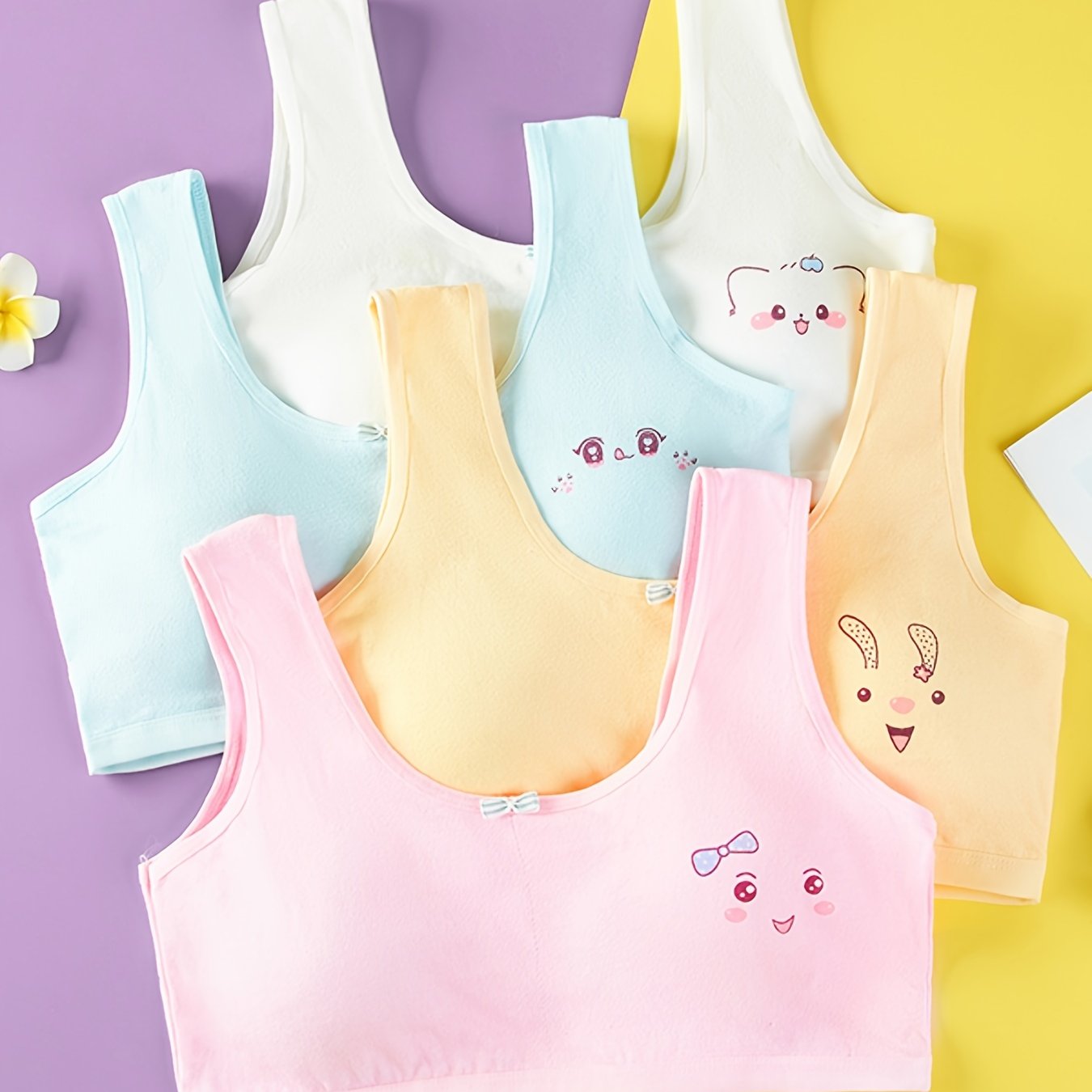 4 comfy cotton bras for girls aged 7-13 with cute animal illustrations in solid colors. Stretchy and machine washable. Includes white, yellow, blue, pink. Ideal for elementary to high