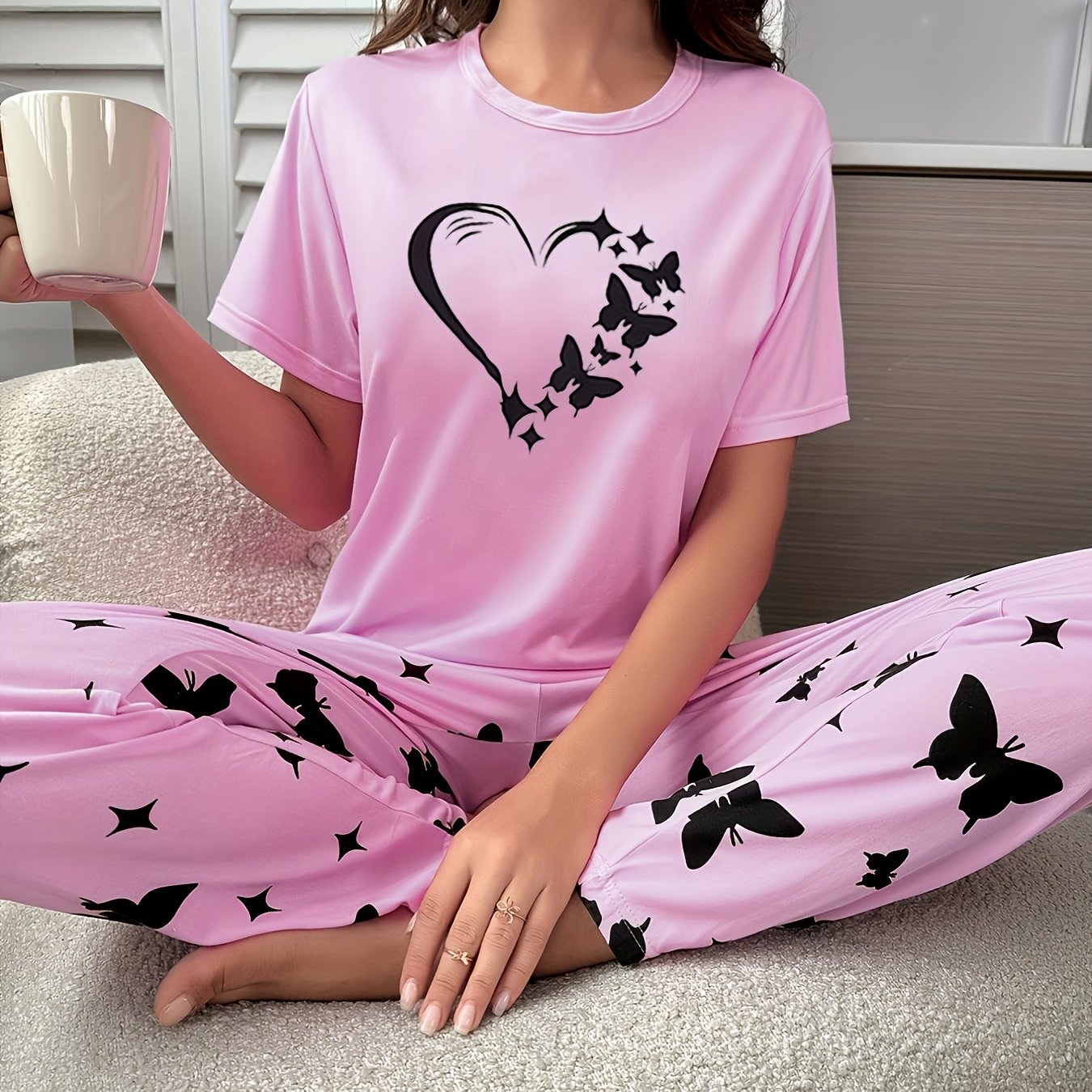 Heart and butterfly print pajama set for women, including a short sleeve top and loose long pants for lounging and sleeping.