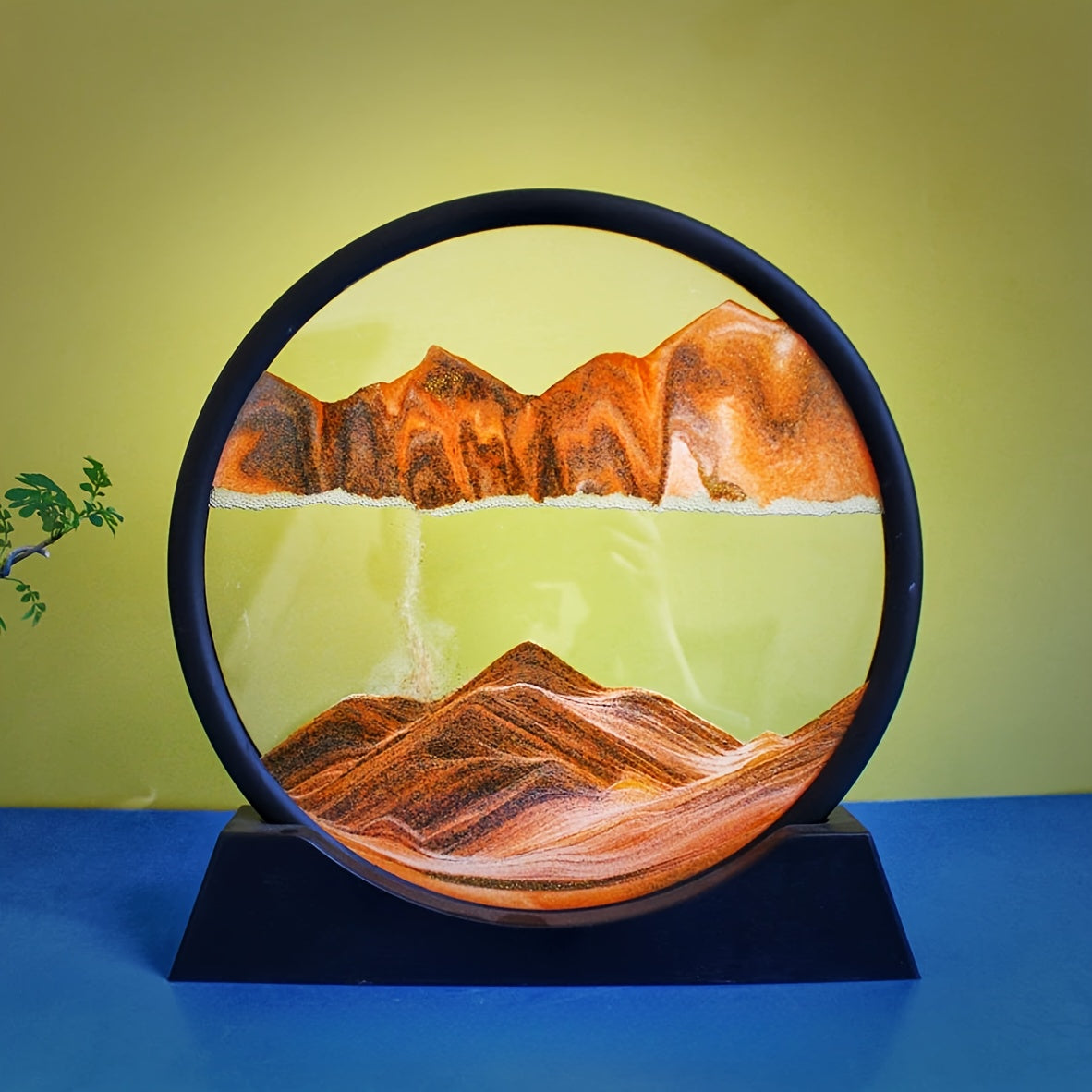 Large round glass frame with flowing sand creates a 3D deep sea scene as a relaxing home and office decoration.