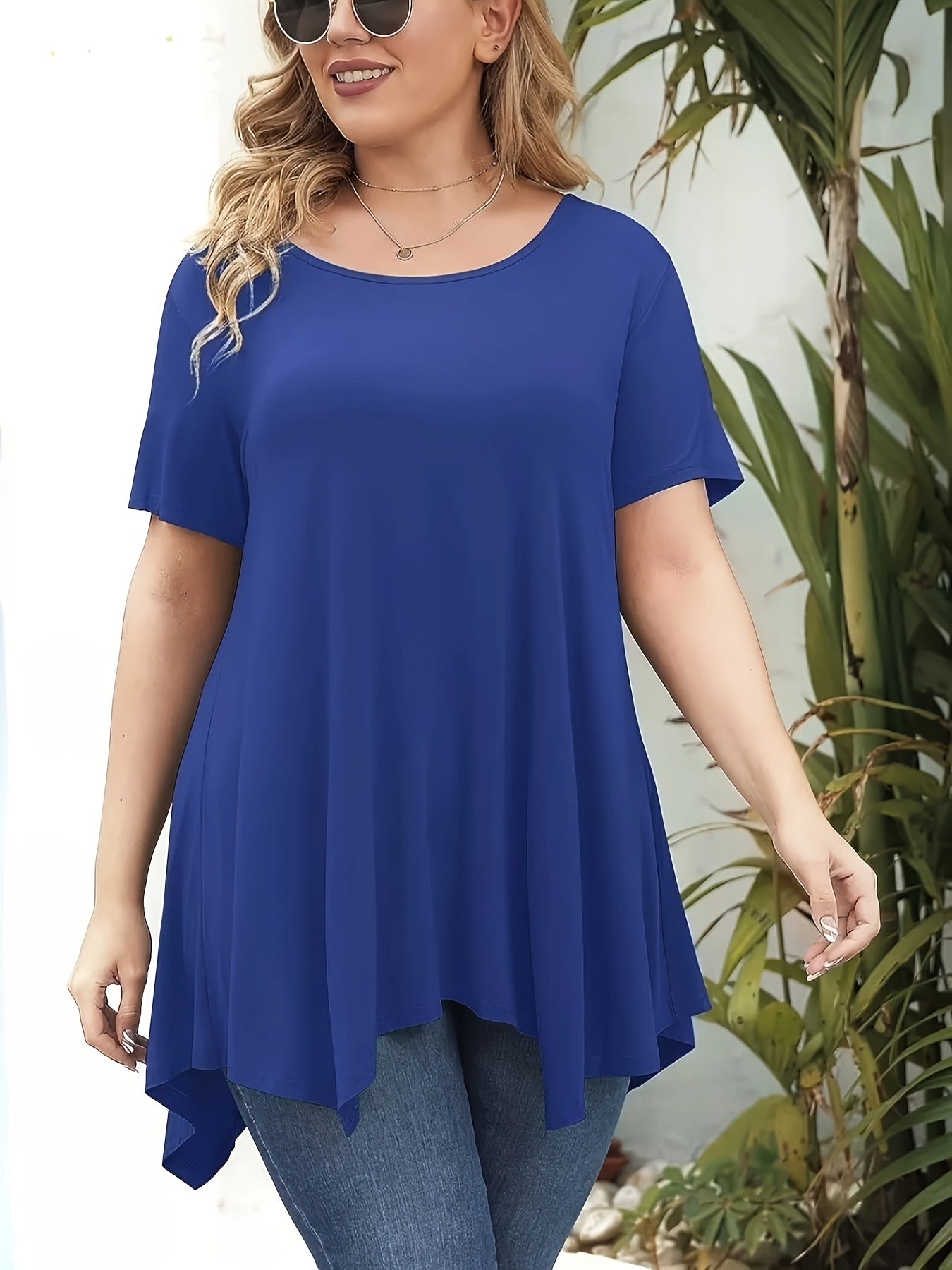 Plus size women's t-shirt with solid color, round neck, irregular hem, short sleeve. Made of polyester and spandex blend, machine washable. From the spring/summer collection.