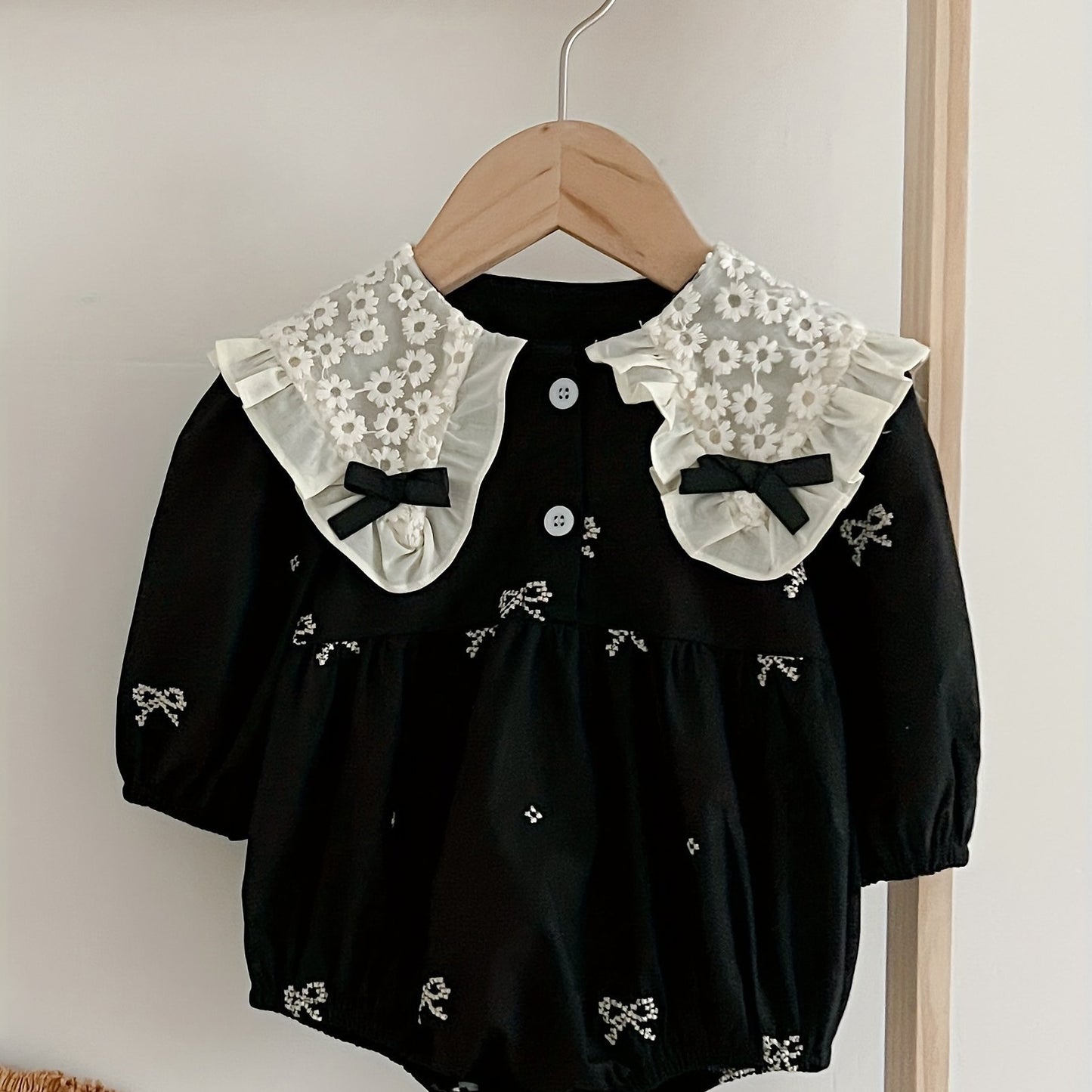 Stylish floral embroidered long-sleeve romper for baby girls, made of cotton with bow detail, ideal for spring/fall and outdoor wear.