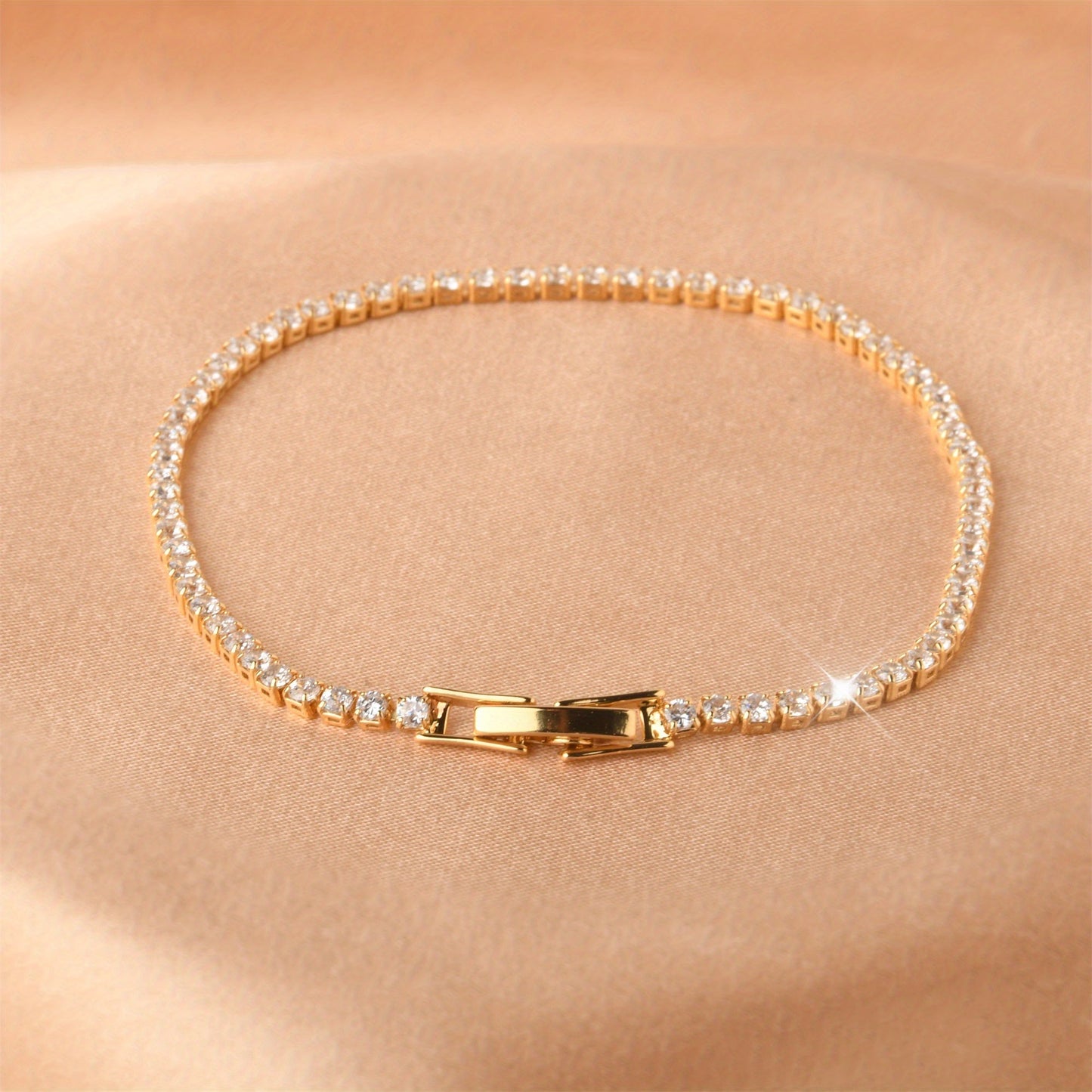 Golden plated copper hand jewelry accessory, featuring inlaid shiny zirconia stones in a tennis bracelet design. Perfect gift for Mother's Day.