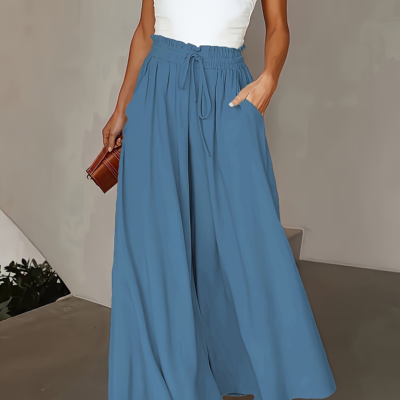 Women's plus size casual wide-leg pants in solid blue with a drawstring waist. Made from a lightweight polyester blend that is machine washable. Ideal for beach or casual wear.