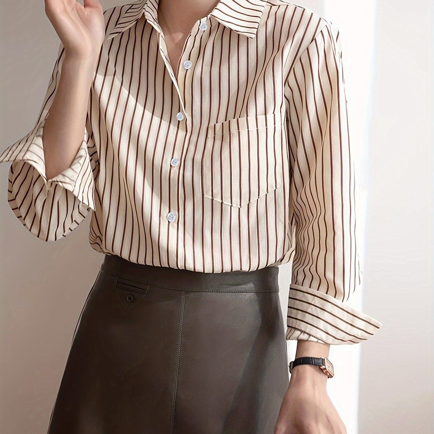 Beige striped blouse with button-up front, loose fit, machine washable.