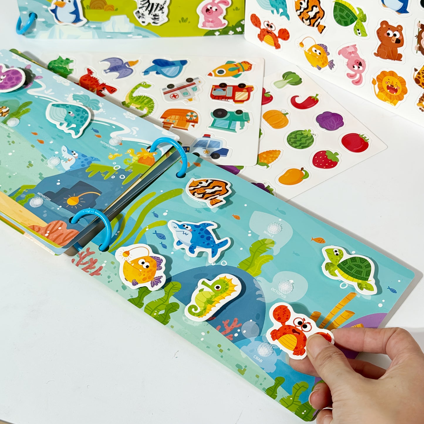 Reusable sticker book with quiet activities focusing on dinosaurs, fruits, animals, oceans, and transportation to improve cognitive, logical, and sensory skills through hands-on DIY tasks.