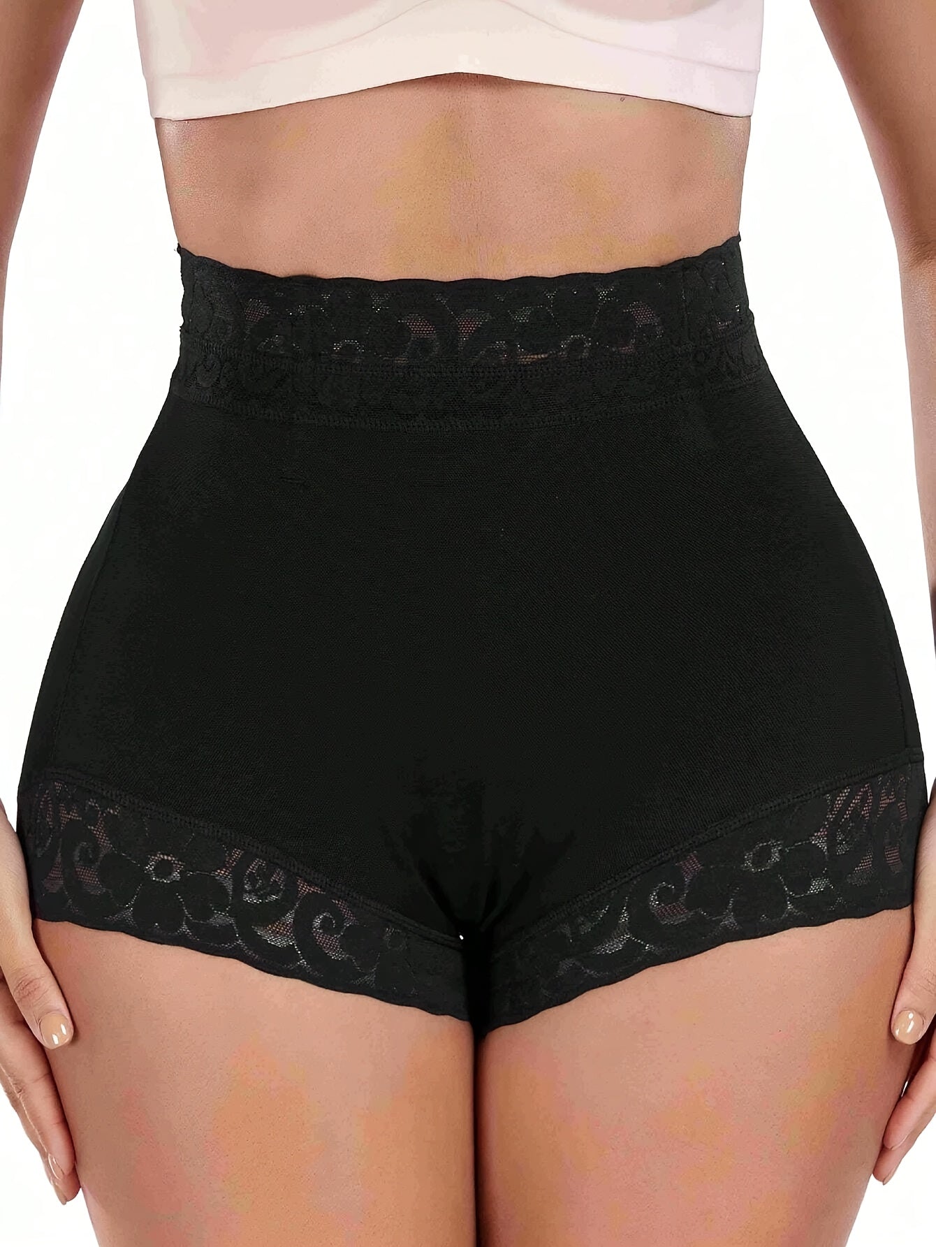 High-waist black shaping shorts with lace detail for tummy control and butt lifting. Made of stretchy nylon and elastane blend. Hand washable with smooth finish. Mid-thigh length and high