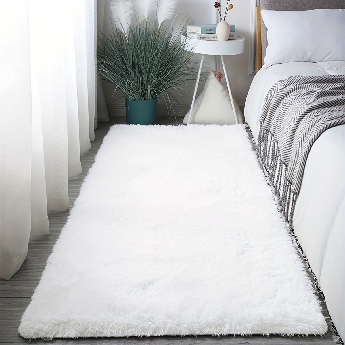 Cozy and luxurious soft white faux fur area rug, featuring a rectangle shape with non-slip backing and stain-resistant properties. This fluffy rug adds a touch of warmth and texture to any bedroom or living room, perfect for indoor use. Made of polyester