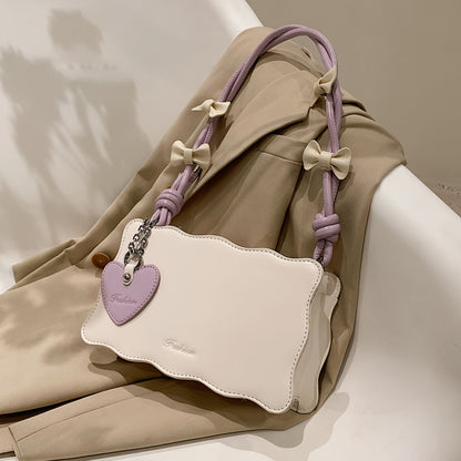 Baguette shoulder bag made of PU material with butterfly bow accents. Versatile and chic fashion accessory.